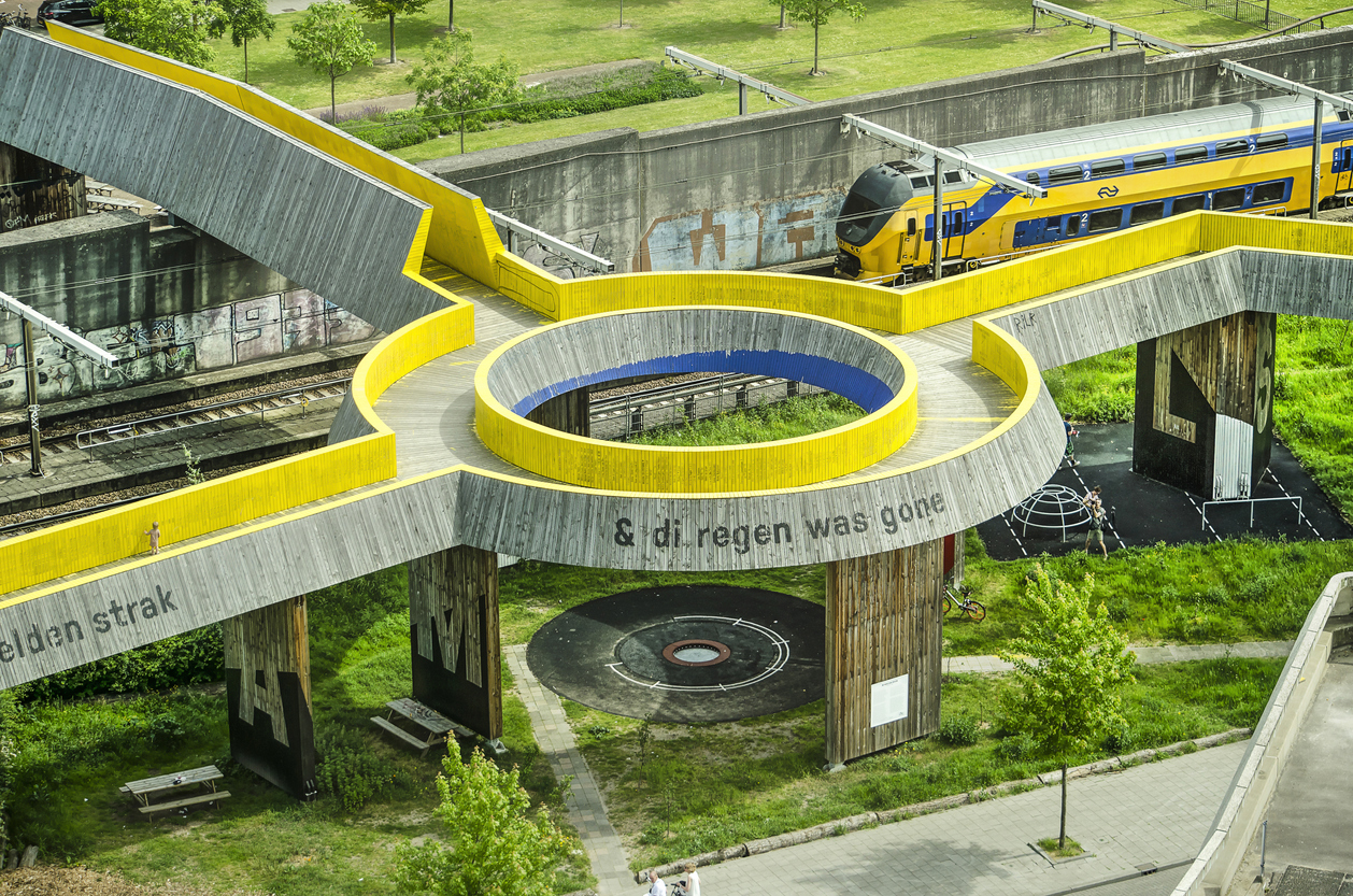 Un train des NS néerlandais passe sous la passerelle Luchtsingel, ce fameux "canal aérien" qui a désenclavé deux quartiers et qui a été réalisé grâce à un financement participatif  © iStock / franswillemblok