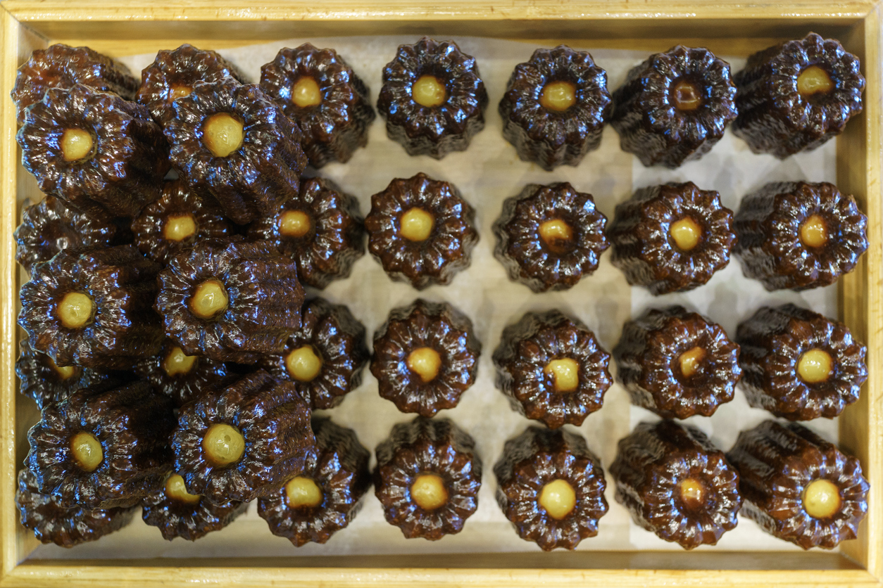 Caneles fraîchement cuits dans un plateau en bois. © iStock / Thai Liang Lim