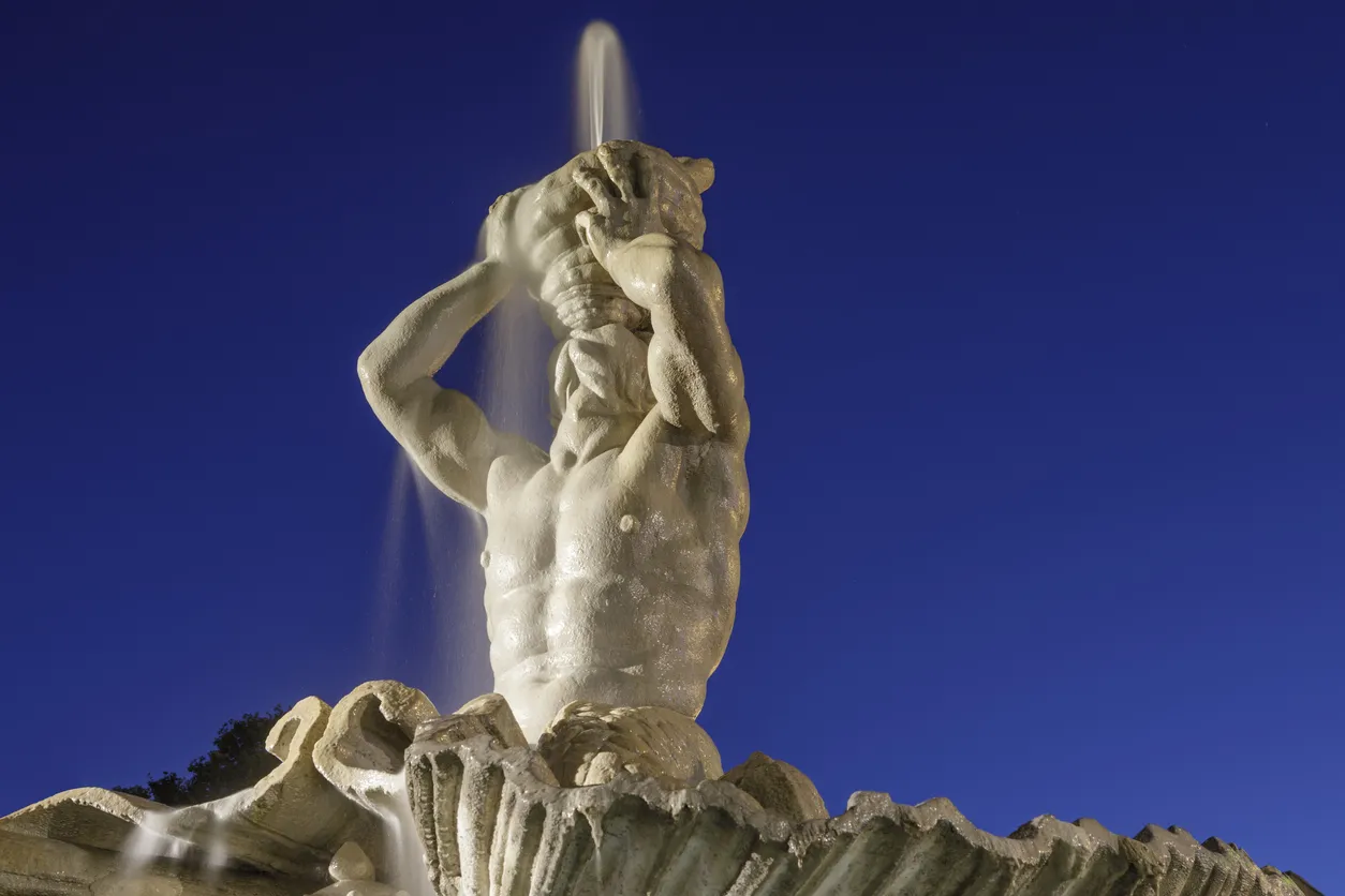 Détail de la fontaine del Tritone, Piazza Barberini, soutenue par quatre dauphins, avec un triton soufflant dans un coquillage  ©  iStock / tunart