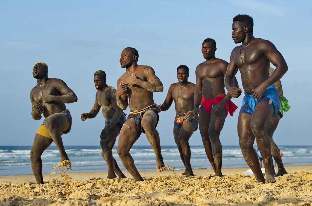 Un groupe de lutteurs sénégalais au bord de la mer © iStock / kaikups
