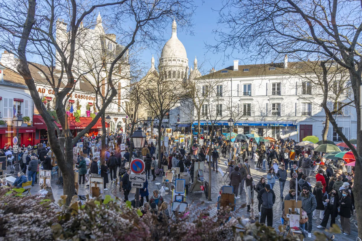 La place du Tertre à Montmartre (Paris). Cette place bohème est un rendez-vous des peintres. A l'arrière-plan, la Basilique du Sacré-Cœur de Paris.  © iStock / Mauro_Repossini