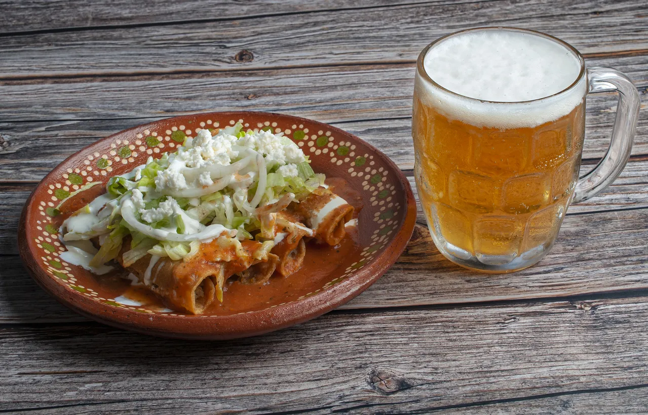 Ttacos dorados avec sauce tomate. fromage, oignon et salsa épicée avec une chope de bière © iStock / Victor Yee