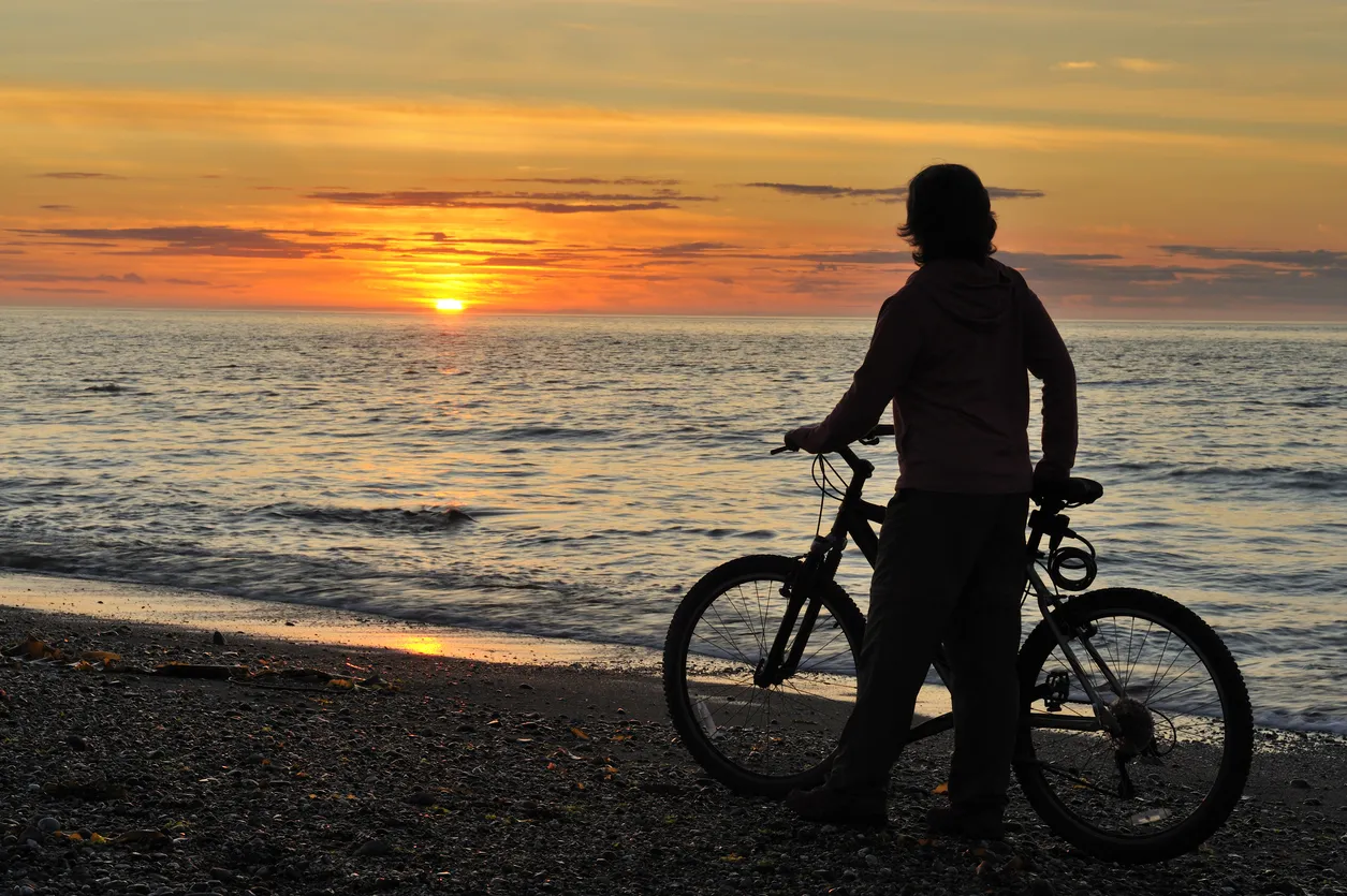 Une randonnée à vélo au bord du fleuve qui se termine par un coucher de soleil © iStock / pchoui