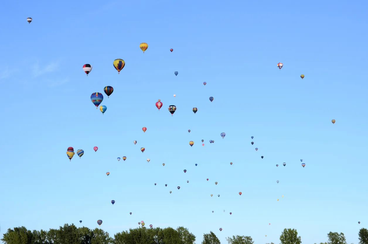 Montgolfières transportant des touristes au-dessus des arbres au Festival international de montgolfières de Saint-Jean-Sur-Richelieu © iStock / kalimf