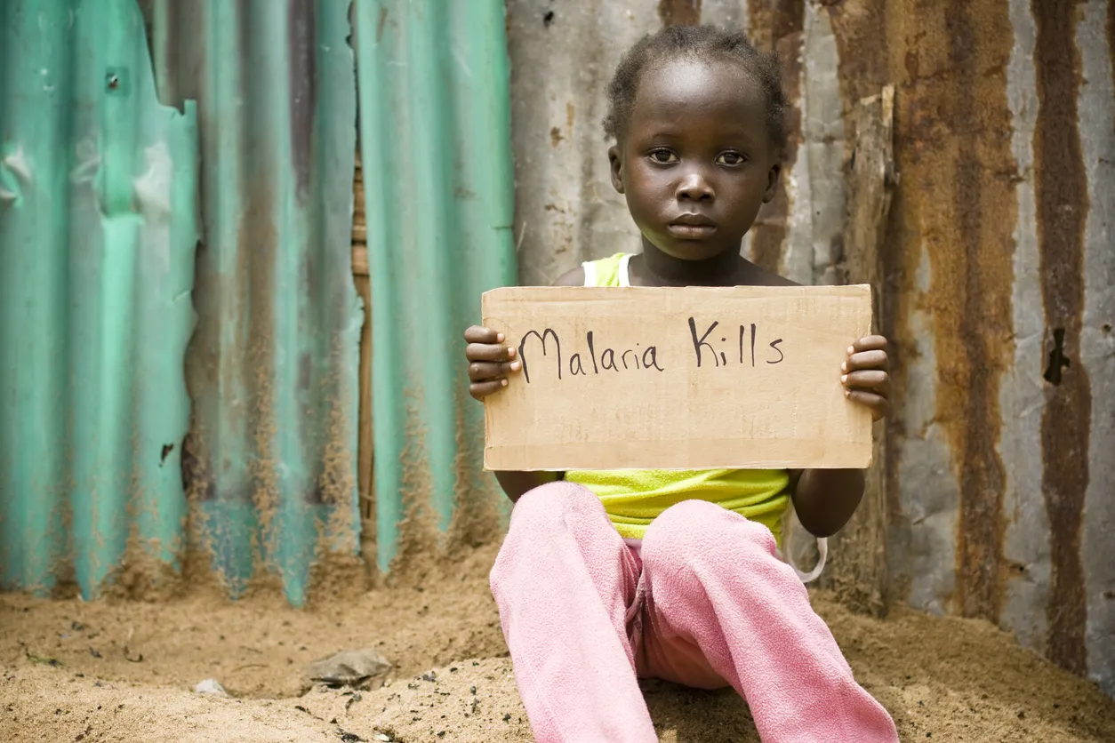 An African girl holding a sign with "Malaria Kills" written on it. @istockphoto/himarkley