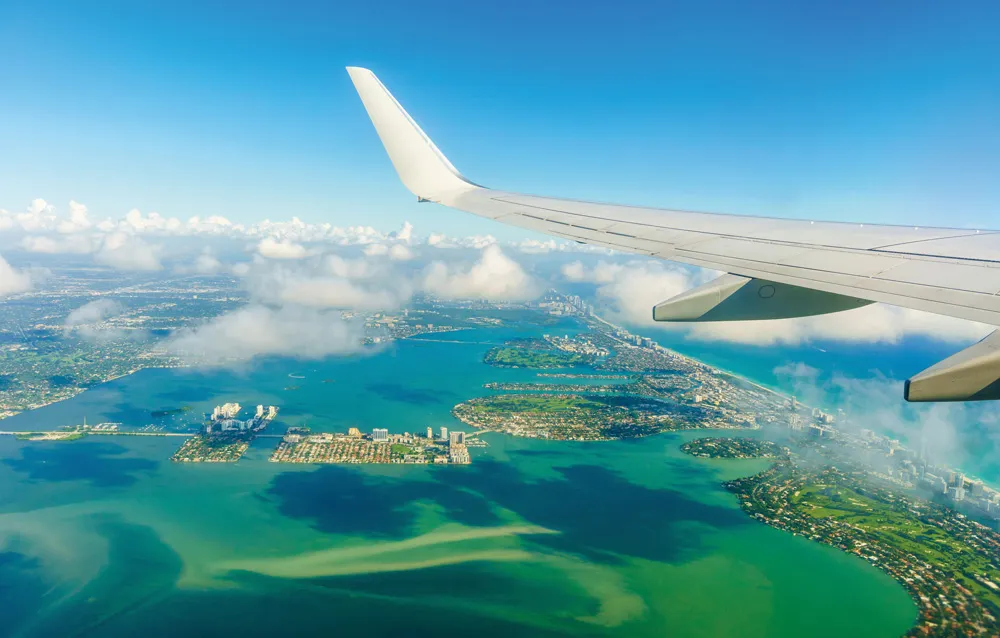 Avion survolant Miami Beach. | © iStockphoto.com/THEPALMER