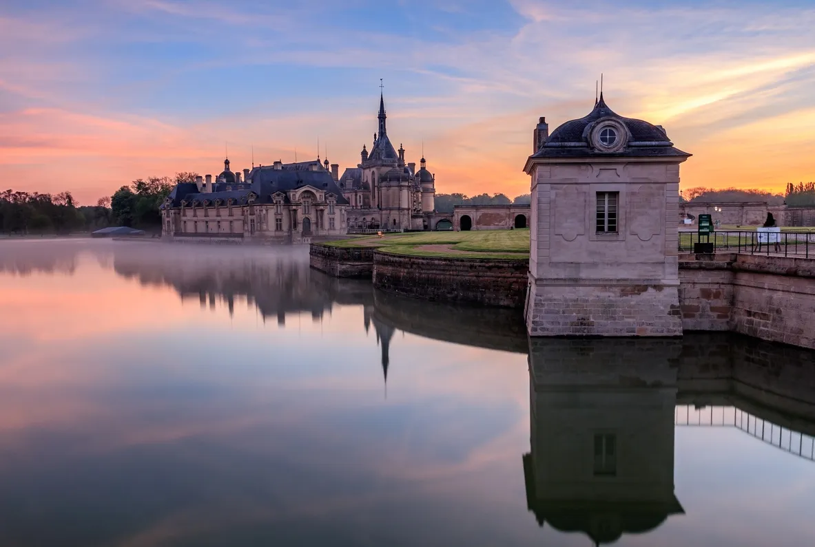 Aurore sur le château de Chantilly avec les couleurs du lever de soleil. © iStock / Michel Hincker